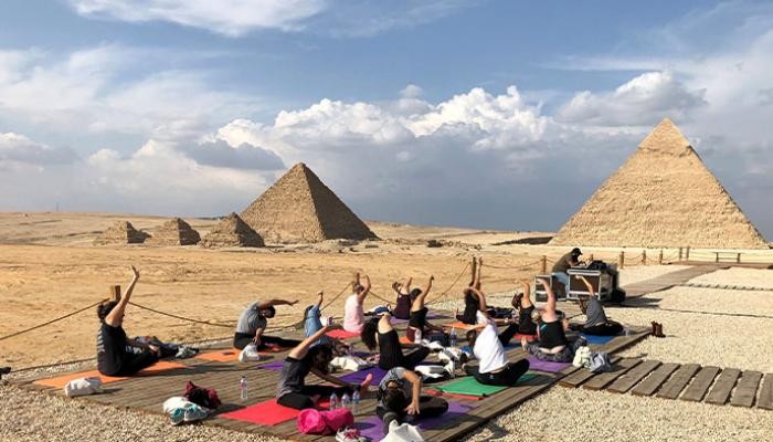 بالصور : ممارسة اليوجا أمام الأهرامات.. رسالة لمواجهة العنف ضد المرأة