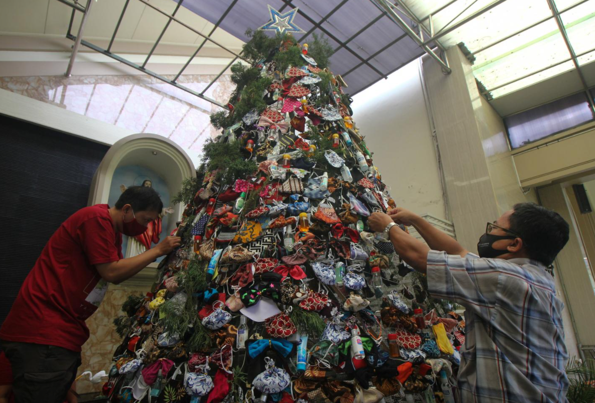 بالصور: شجرة كريسماس عملاقة تتزين بالكمامات ومعقمات الأيدي فى كنيسة إندونيسية