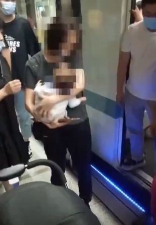 شاب صينى ينقذ طفلا رضيعا سقط من أمه بين قطار المترو والرصيف