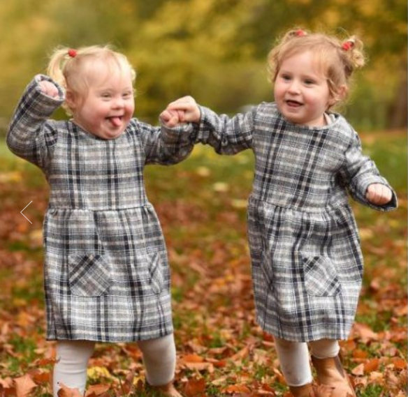 طفلة بريطانية تساعد شقيقتها التوأم المصابة بـ"داون" على المشى