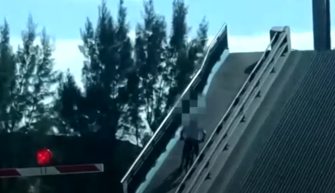 موقف محرج لراكب دراجة يمر فوق جسر لحظة فتحه وانقسامه لنصفين