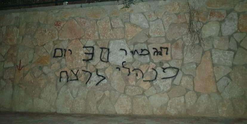 مستوطنون يحرقون مركبات ويخطّون شعارات عنصرية في أبو غوش