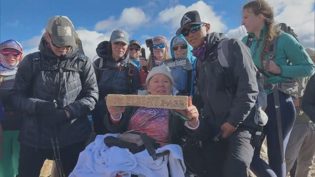 على كرسي متحرك... أمريكية تتسلق قمة جبل إلبرت بمساعدة متطوعين