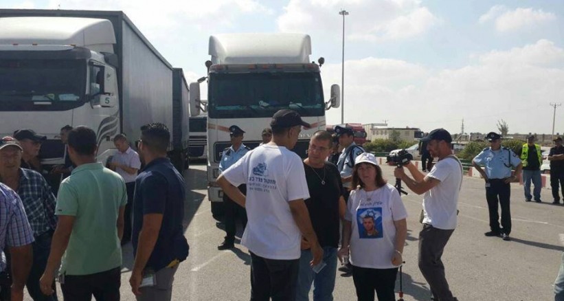 بالصور: عائلة الجندي "شاؤول آرون" تعطل حركة الشاحنات على معبر كرم أبو سالم