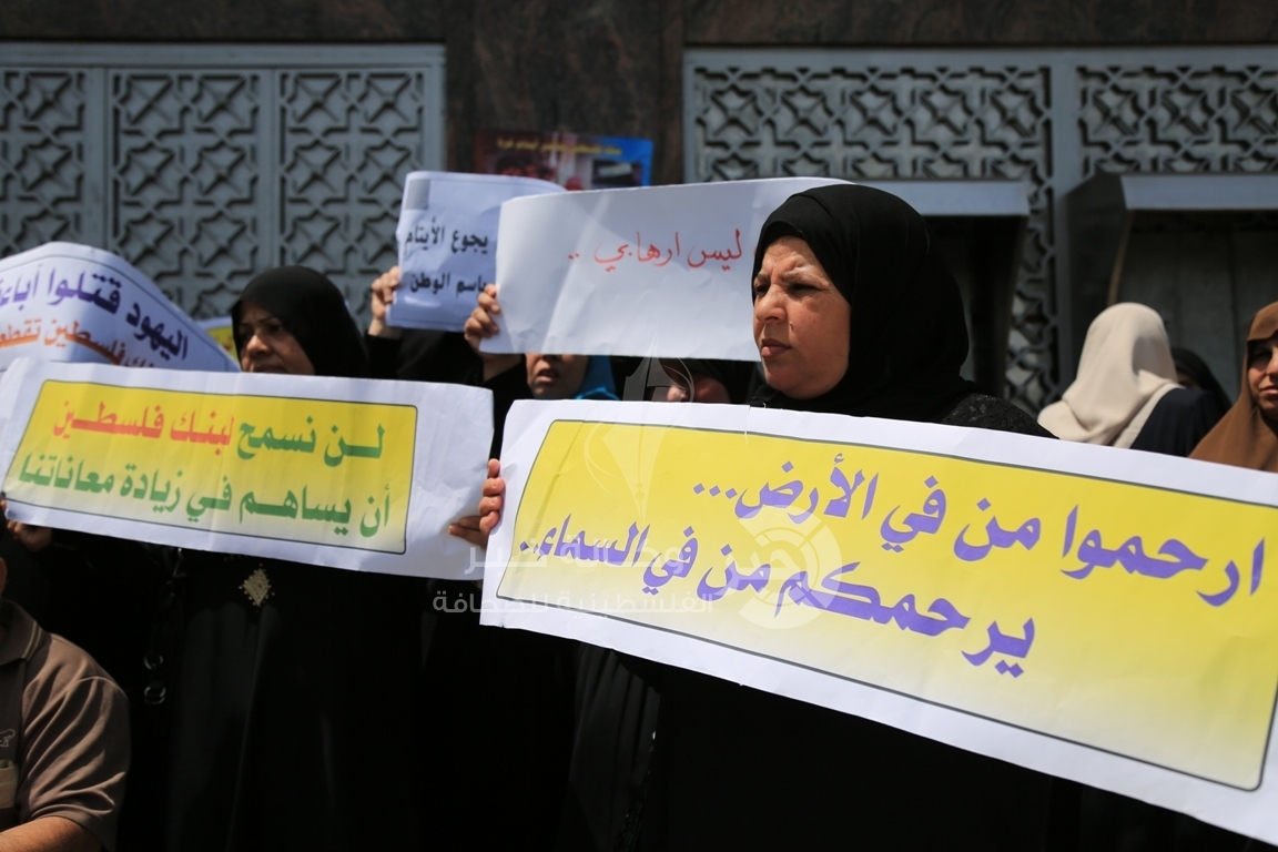 بالصور ... أهالي الشهداء والأيتام يهددون بإغلاق مقرات بنك فلسطين